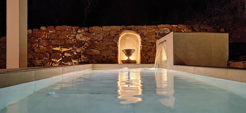 a pool of water with a stone wall at Las estrellas del duende in El Gastor