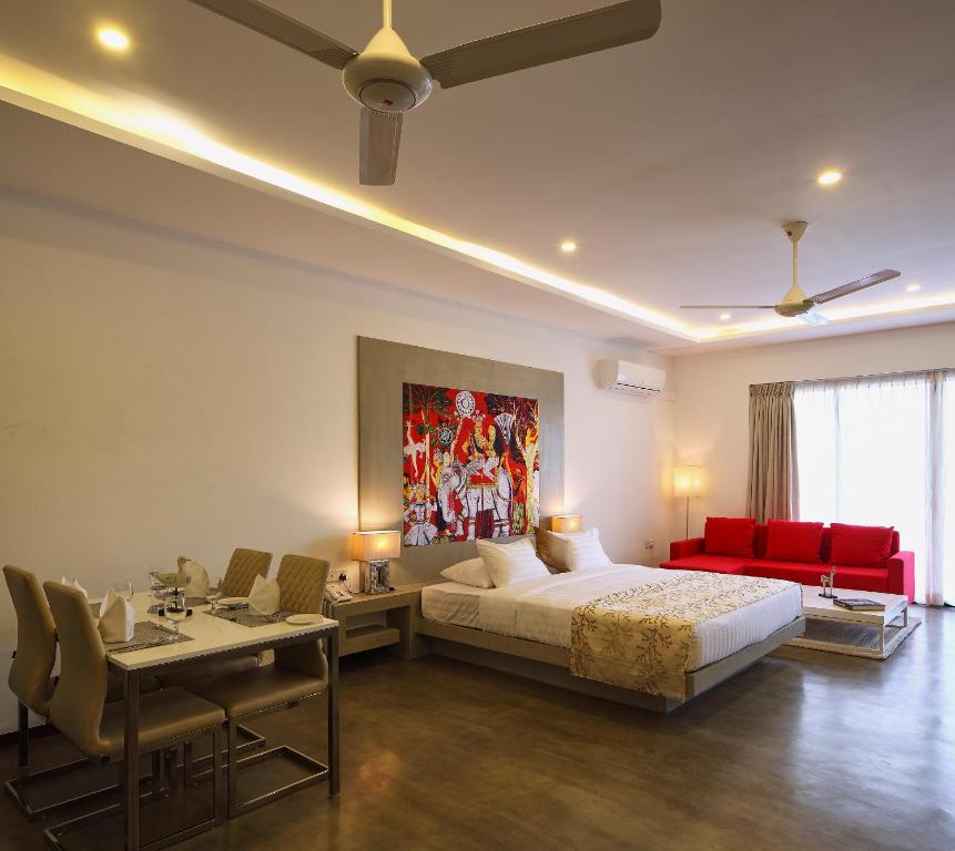 a bedroom with a large bed and a red couch at Serendiva Beach in Wadduwa
