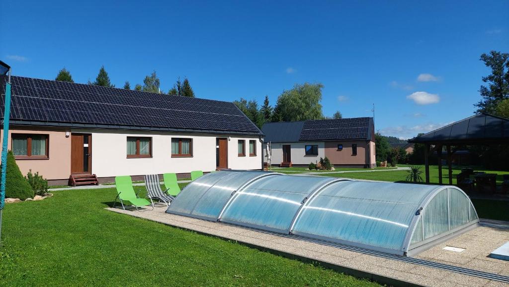 a greenhouse in a yard next to a house at Apartmány U Potoka in Dolní Moravice