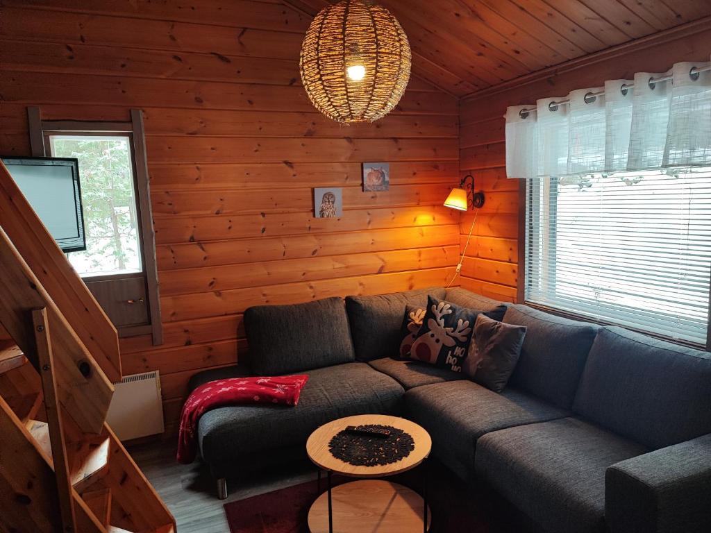 a living room with a couch in a log cabin at Vuosselintähti 8 B in Ruka