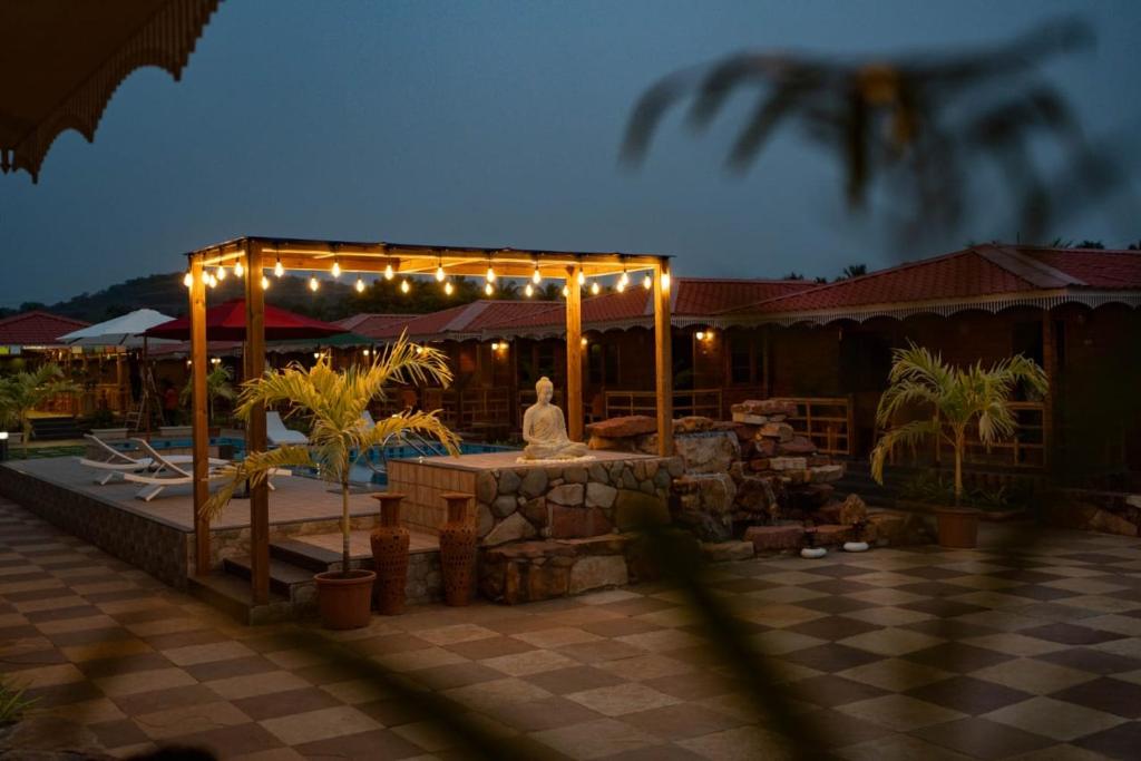a patio with a statue under a tent with lights at Grace Exotica Goa in Canaguinim