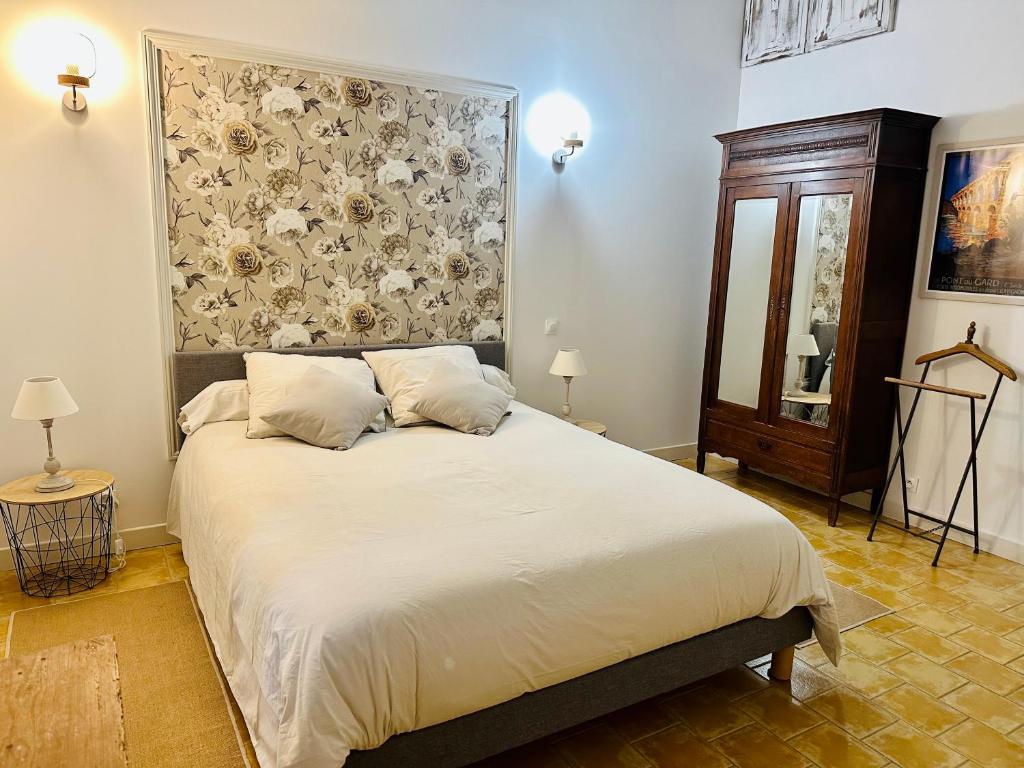 a bedroom with a large bed with a floral headboard at Le Pavillon Vert - B&B in Vedène