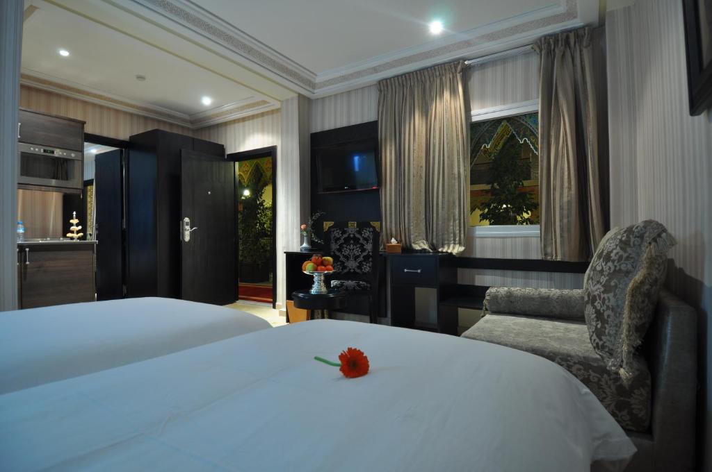 Palais Riad Reda & Spa في فاس: غرفة نوم بسرير ابيض كبير وكرسي