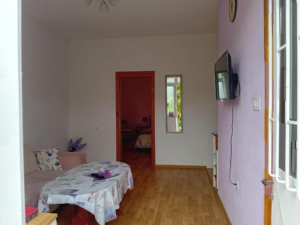 Habitación con mesa y TV. en Apartman Lavanda, en Trebinje