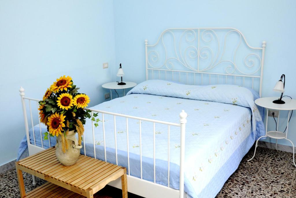 a blue bedroom with a bed with a vase of flowers at Casa Giordano in Tramonti