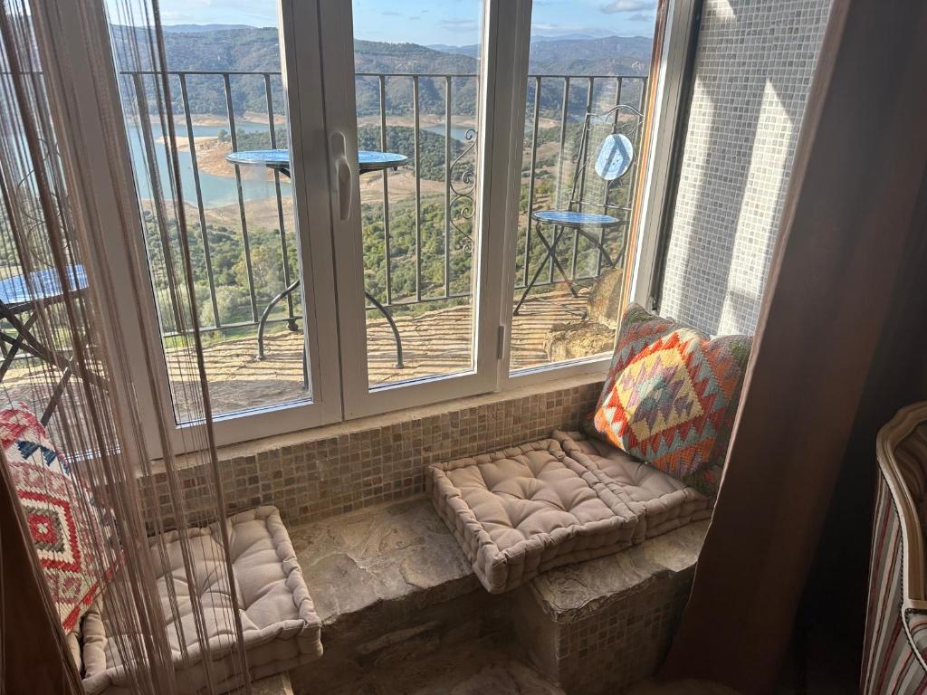 um assento na janela com um sofá com vista para a vista em Balcon de los Amorosos em Castellar de la Frontera