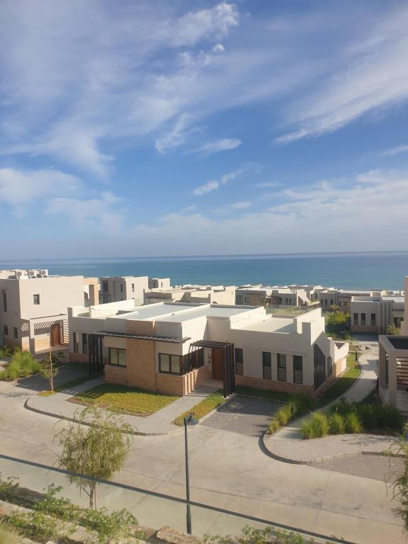 uma fila de casas com o oceano ao fundo em Peace in Sifah -Sea view em As Sifah