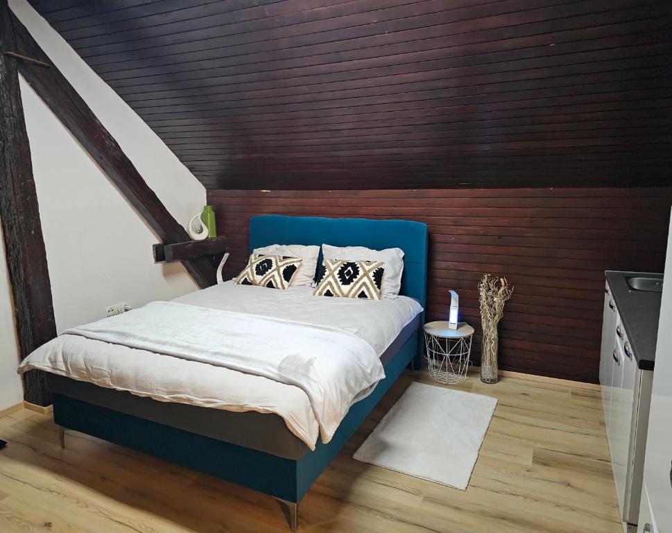 a bedroom with a blue bed and wooden walls at Soba 7 Pekrska vila in Limbuš