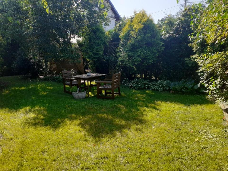 a garden with a table and chairs in the grass at domek dla 2 osób in Junoszyno