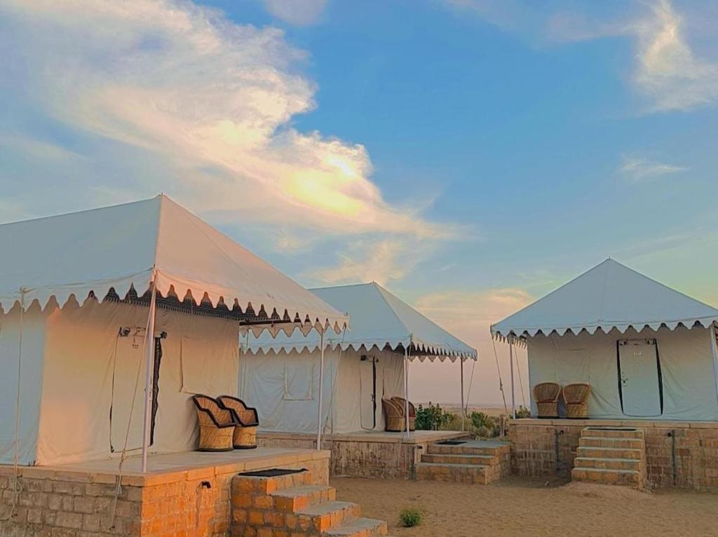 two white tents with blue roofs on a beach at Desert Safari Camp & Resort Sam in Sām