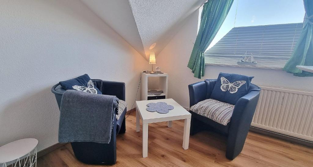 een woonkamer met 2 stoelen en een tafel bij Dunja Whg 1 in Grömitz