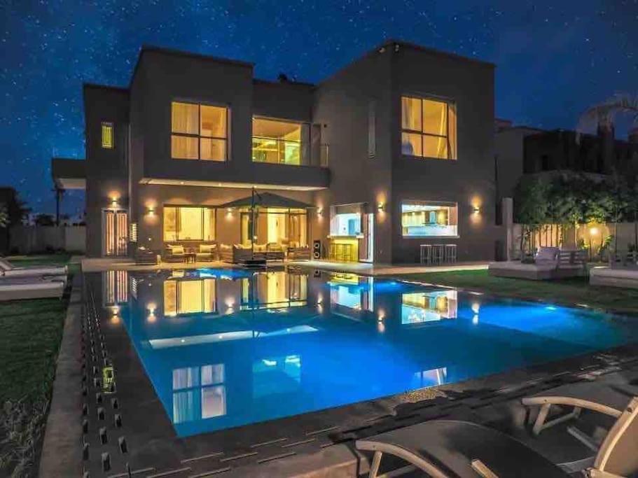 - une piscine en face d'une maison la nuit dans l'établissement Eden Villa, à Marrakech