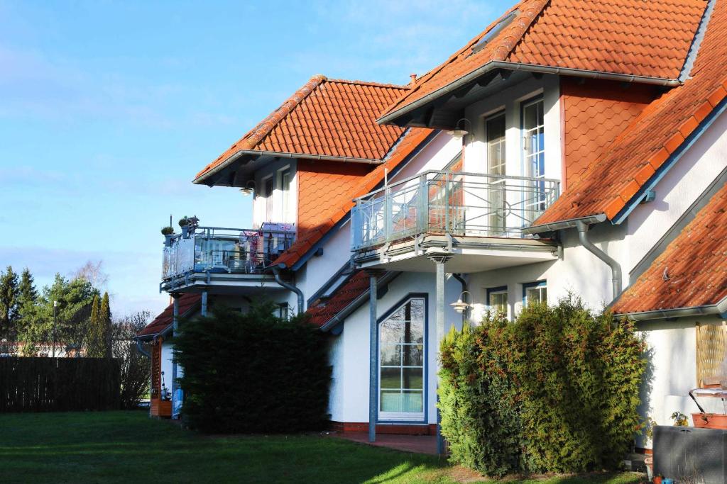 オストゼーバート・カールスハーゲンにあるFewo Peeneblick 5_LINDのオレンジ色の屋根の白い家