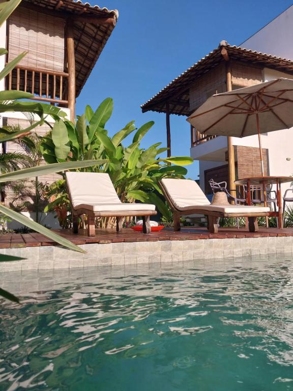 un complexe avec une piscine, des chaises et un parasol dans l'établissement Casa Paula, à Barra Grande