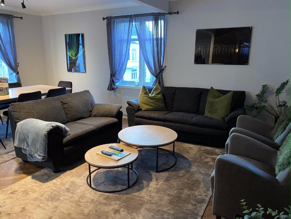 a living room with two couches and a table at Enter Tromsø - Luxury 4 Bedroom Apartment in Tromsø