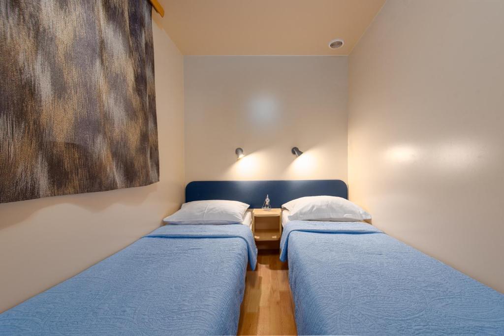 dwa łóżka w pokoju z obrazem na ścianie w obiekcie CAMP MRKVA MOBILE HOMES with POOL w Sukošanie