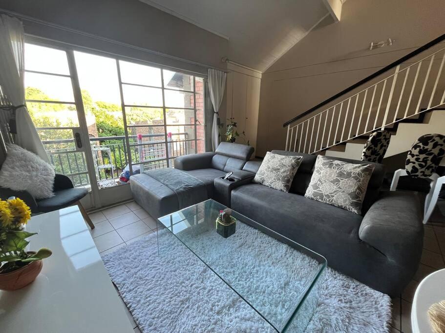 een woonkamer met een bank en een tafel bij Executive suite@Lofts in Pretoria