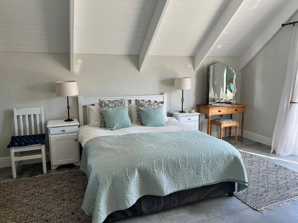 a bedroom with a bed with blue pillows and a mirror at A Mountain & Country Haven in Stanford