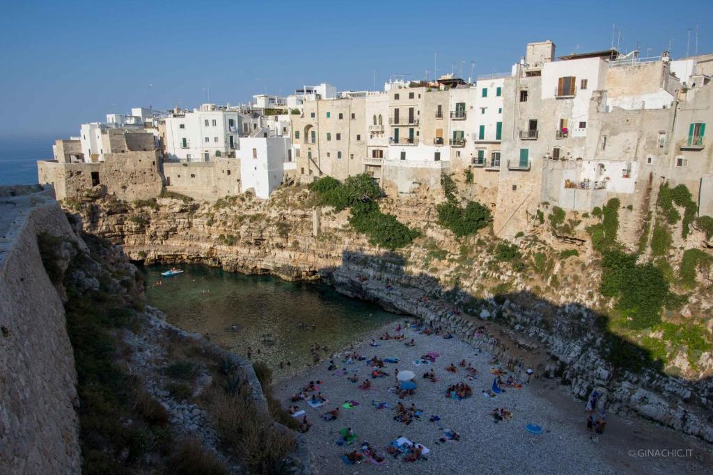 a group of people on a beach in front of a city at Calaporto-Holiday Home & Relax in Polignano a Mare
