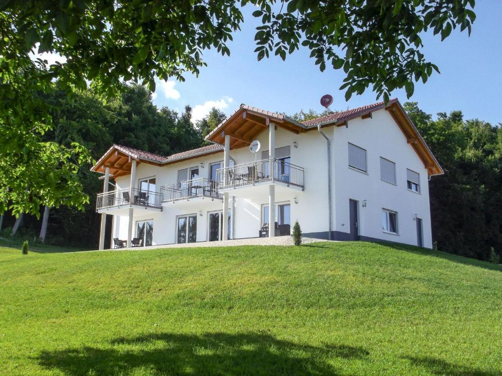 ein großes weißes Haus auf einem grasbewachsenen Hügel in der Unterkunft Hof am Horn - Fewos in der Natur in Laichingen