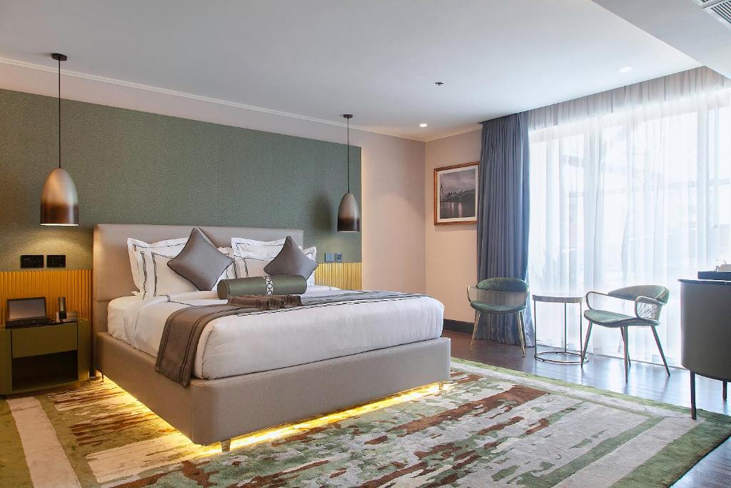 1 dormitorio con 1 cama, mesa y sillas en Best Hotel in Lagos - The Delborough, en Lagos