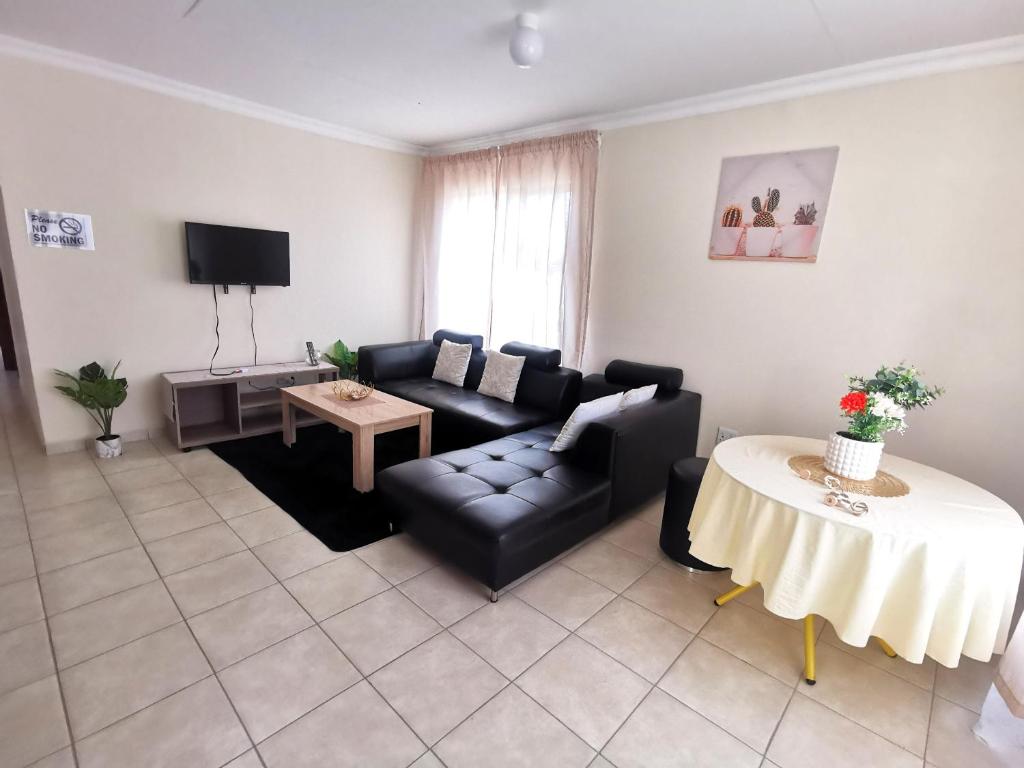 a living room with a couch and a table at MV self-catering - Units in Bloemfontein