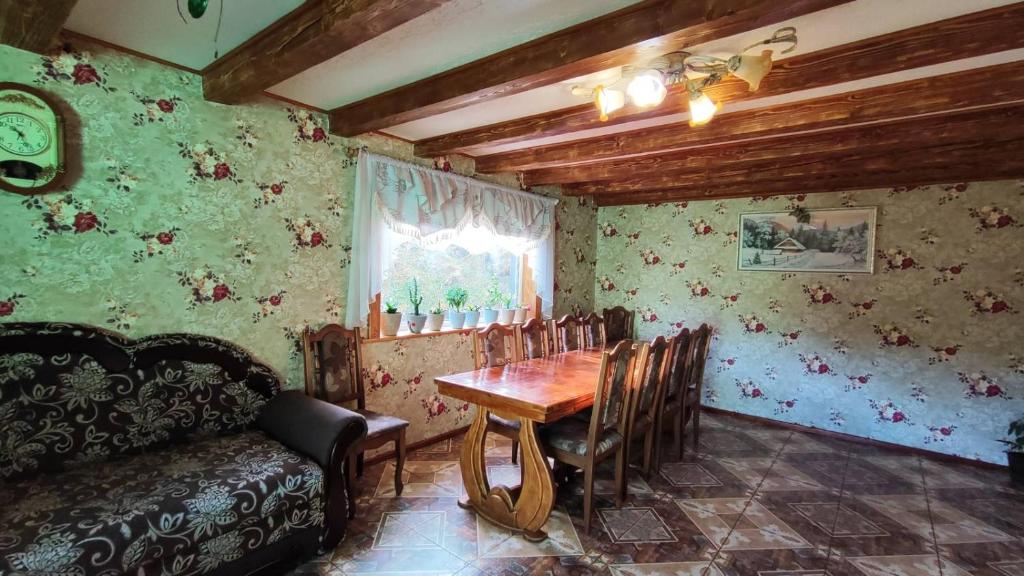 a dining room with a table and chairs and a couch at У Василини in Yablunytsya