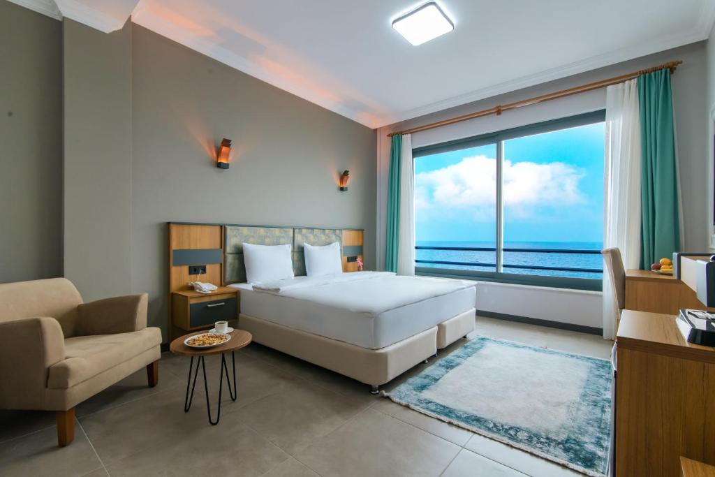 een slaapkamer met een bed en een groot raam bij Fevzi Hoca Butik Hotel in Trabzon