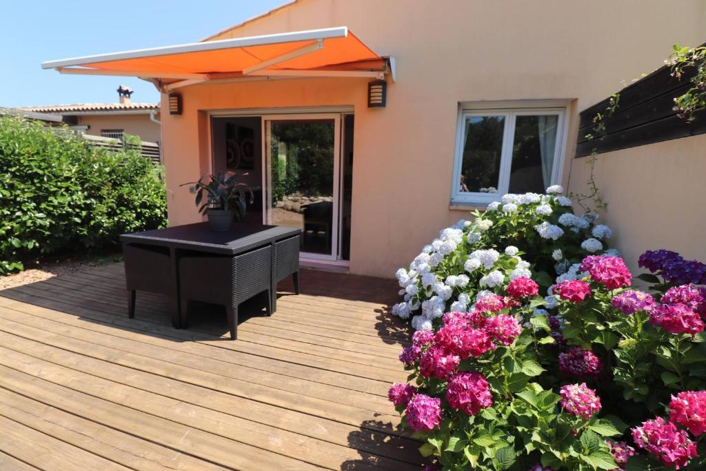 une terrasse en bois avec un piano et des fleurs dans l'établissement Accommodation Close To Pinarello Beach, à Conca
