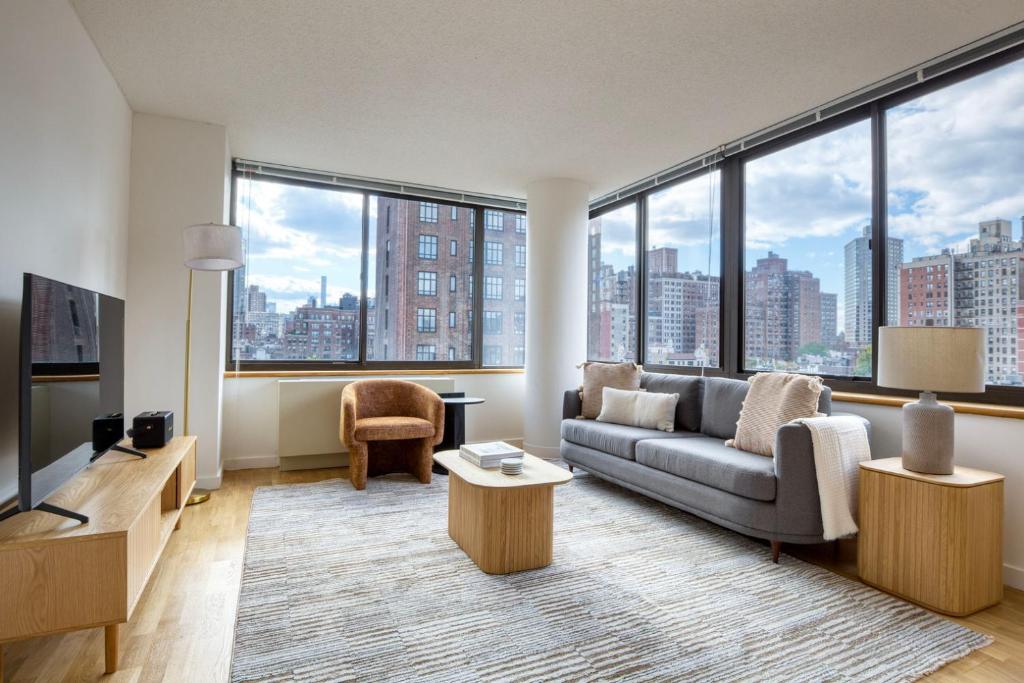 a living room with a couch and a large window at UES 2br w elevator doorman nr transportation NYC-1297 in New York
