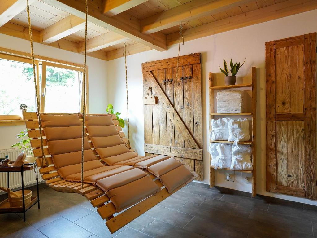 uma cadeira de baloiço num quarto com tectos em madeira em Heimatglück em Lautenbach