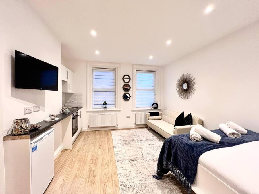 een witte kamer met een bed en een bank bij The Beach House, The Kove, Bournemouth Beach in Bournemouth
