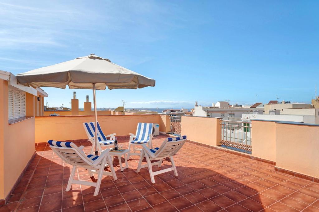 a patio with a table and chairs and an umbrella at Isla Bonita San Juan Beach in Guía de Isora