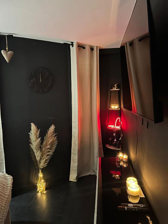une chambre avec une table, une horloge et une lampe dans l'établissement Suite64 - Jacuzzi privatif, à Neuilly-sur-Seine