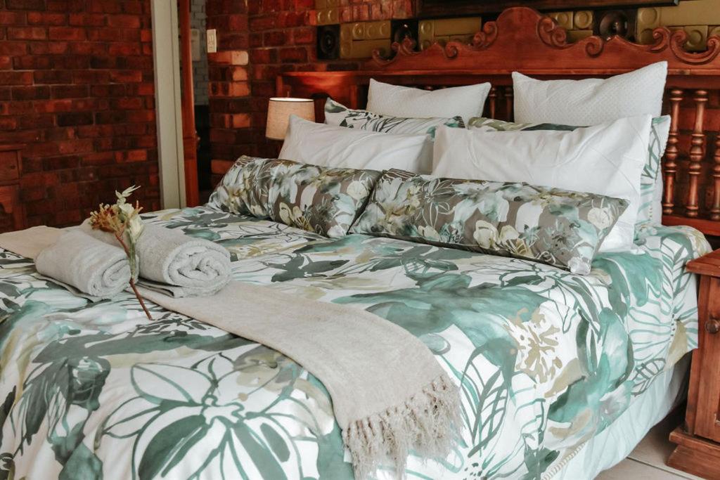 a large bed with a green and white comforter at MFT GUEST HOUSE in Boksburg