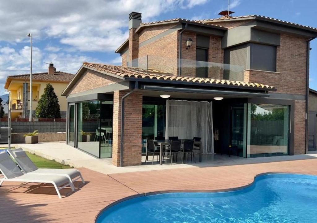 a house with a swimming pool and a patio at Chalet Els pins, Banyoles in Banyoles