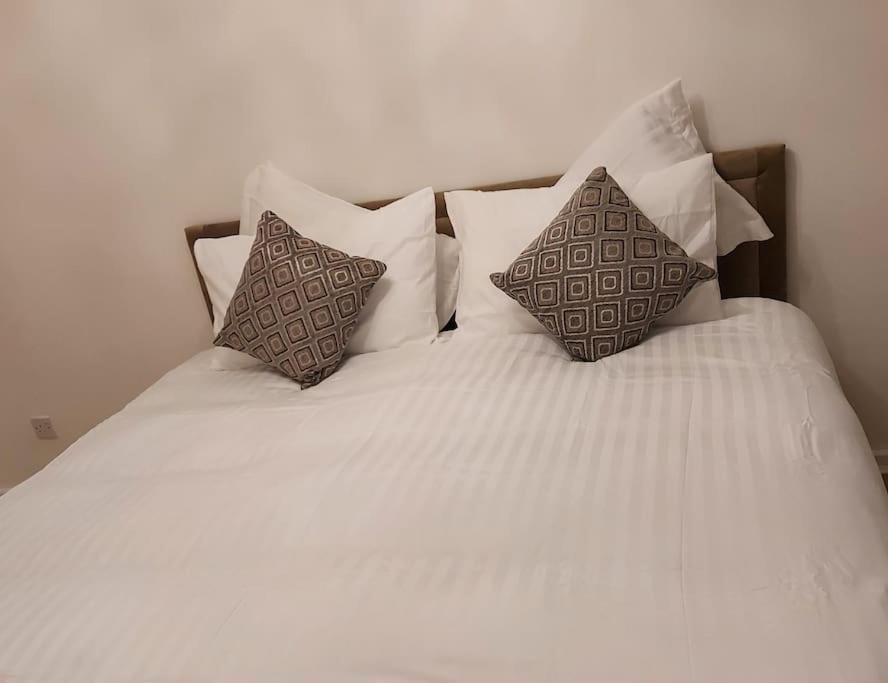 a white bed with two pillows on top of it at The Rose in Greasbrough