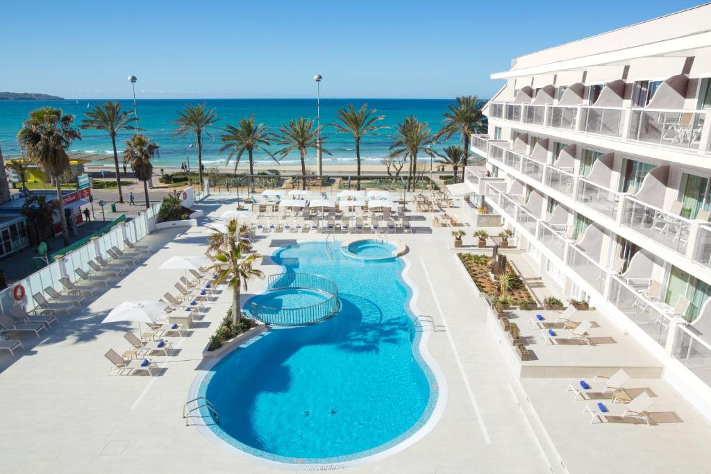 プラヤ・デ・パルマにあるUniversal Hotel Neptuno - Adults Onlyのスイミングプールとビーチのあるリゾートの空からの景色を望めます。