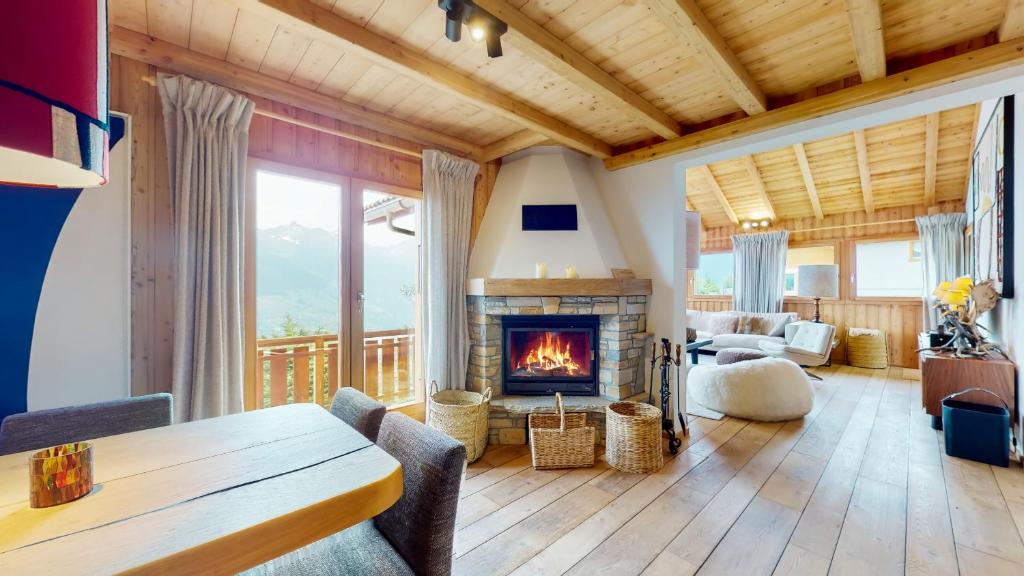 a living room with a fireplace and a table at Arnold COCOONING & VIEW chalet 12 personnes Les Masses in Les Collons