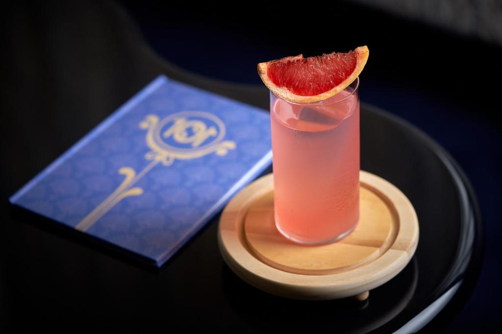 a drink with a slice of grapefruit on a table at Grand Hotel Principe Di Piemonte in Viareggio