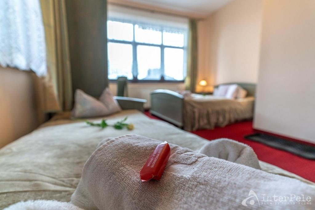 Towel with wrapped candy in foreground, blurred beds and window creating cozy mood.