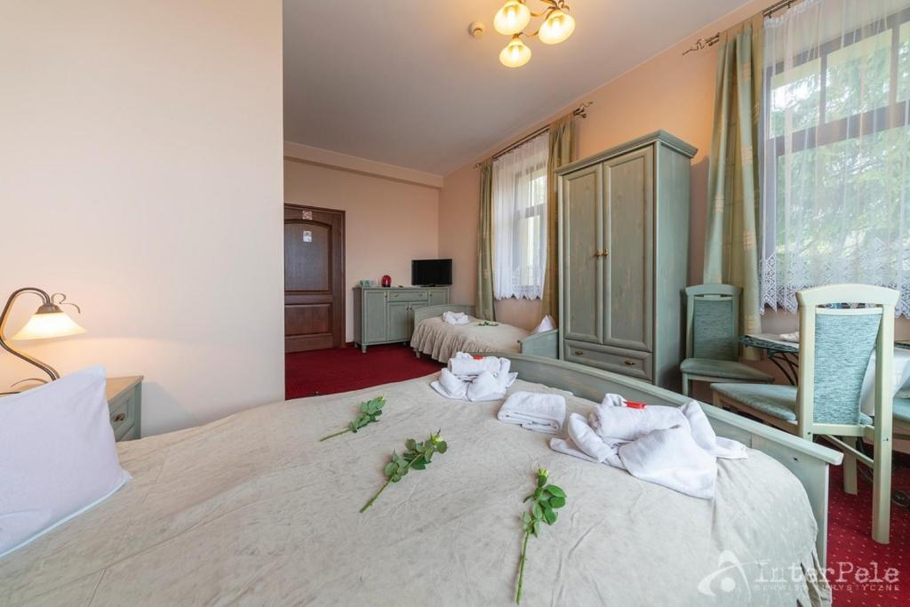 Comfortable room with double bed, wardrobe, chairs, and roses laid on bed.