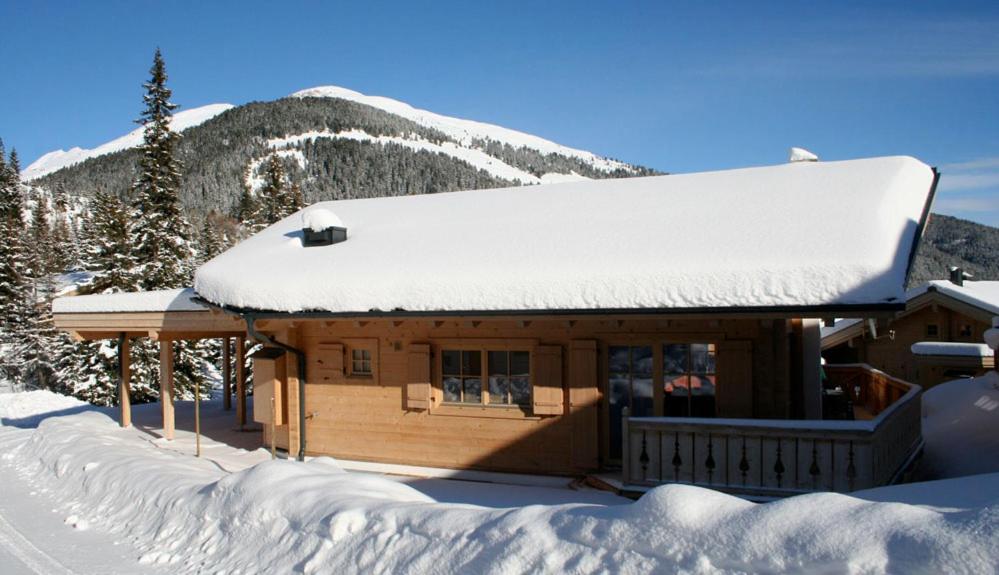 a log cabin with snow on the roof at Chalet Schneespaß in Königsleiten
