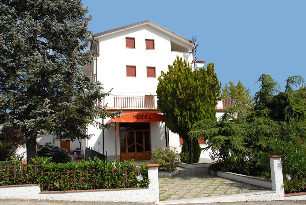 un gran edificio blanco con árboles delante de él en Hotel Del Duca, en Montedinove