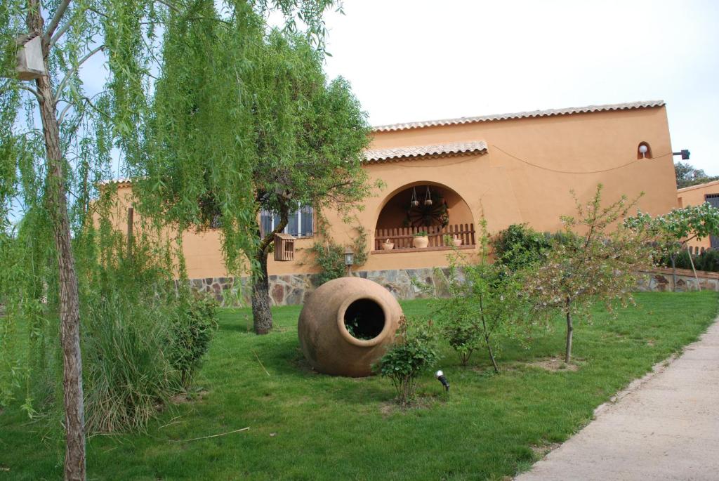 a house with a large tire in the yard at El Rincón de Cabañeros in Retuerta de Bullaque