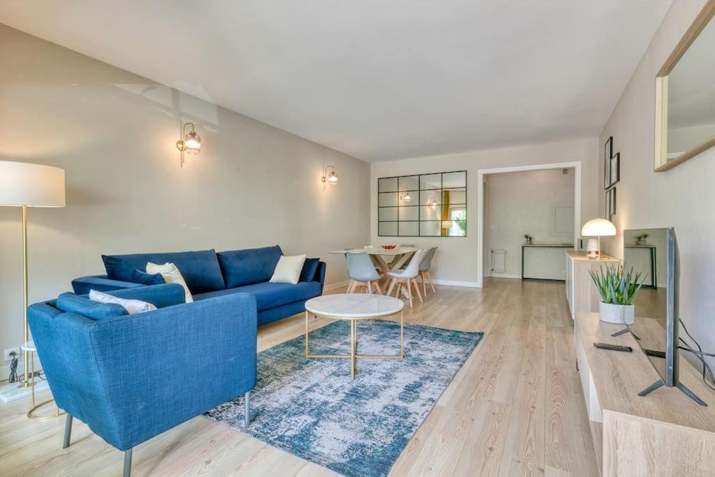 un salon avec un canapé bleu et une table dans l'établissement Vue mer La Baule : L'escale Bauloise, à La Baule