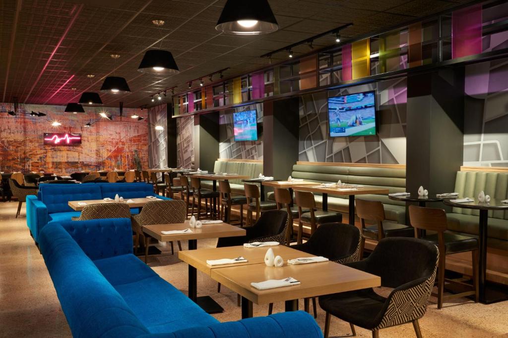 a restaurant with blue couches and tables and televisions at Delta Hotels by Marriott Toronto Airport & Conference Centre in Toronto
