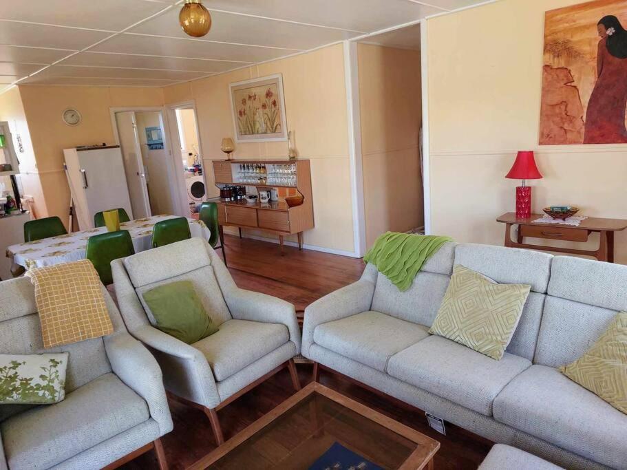 uma sala de estar com dois sofás e duas cadeiras em Gidget's Place em Surf Beach