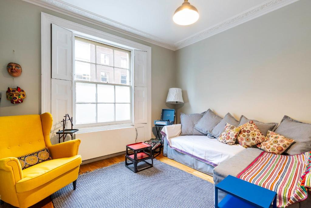 a living room with a couch and a yellow chair at Beautiful two-bed abode Near King Cross in London