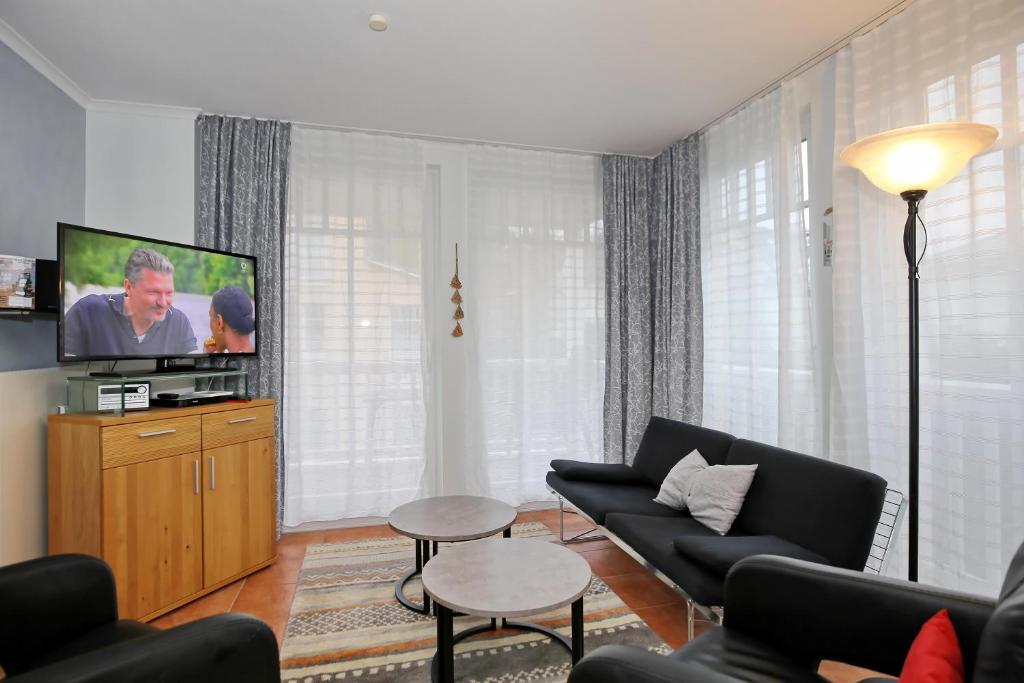 a living room with a couch and a flat screen tv at Dünenschloss Wohnung 2-11 in Kühlungsborn